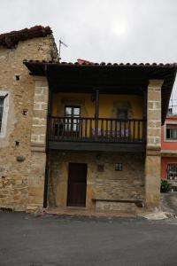 - un bâtiment avec un balcon sur le côté dans l'établissement Casa Rural Moradiellos, à Arenas de Cabrales