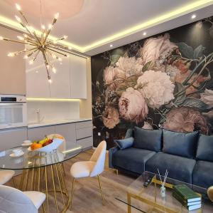 un salon avec un canapé bleu et une fresque florale dans l'établissement Sospiro apartments, à Split