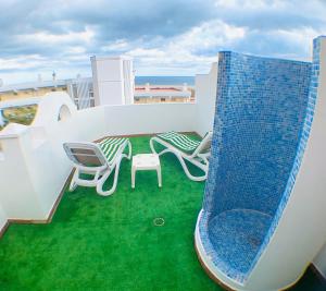 a balcony with chairs and a slide on a roof at Ohana in Morro del Jable