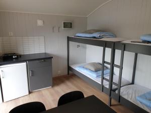 a room with two bunk beds and a table at Tvinde Camping in Skulestadmo