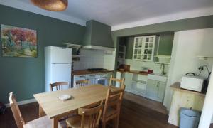 a kitchen with a table and chairs and a refrigerator at Gite Aoura baronnies provençales in Montjay