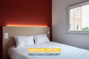 uma cama num quarto de hotel com uma janela em Premiere Classe Beaune em Beaune