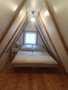 a bed in a small room with a window at Domek na Mazurach Leśne Zacisze in Ostaszewo