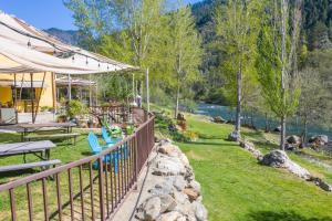 a backyard with a fence and chairs and a river at Strawhouse Resorts in Big Bar