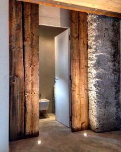 un bagno con pareti in legno, porta e lavandino di Chalet Ca d'Martin a Vicosoprano