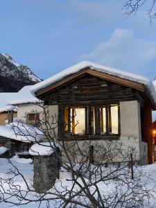 a house with snow on top of it at Chalet Ca d'Martin in Vicosoprano