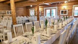 una mesa larga en una habitación con mesas y sillas blancas en Jaszowianka Best For You en Ustroń