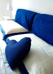 ein blaues Kissen auf dem Bett in der Unterkunft Casa Cornice in Arma di Taggia
