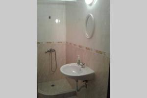 uma casa de banho com um lavatório e um chuveiro em Приятный отдых в студии на море в Сарафово em Burgas