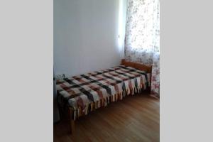 a small bed sitting in a corner of a room at Приятный отдых в студии на море в Сарафово in Burgas