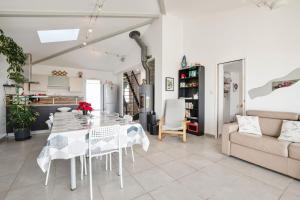 comedor blanco con mesa y sofá en Villa Lavande, en Yves