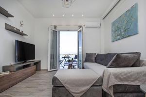 Vidos Seaview Suite في مدينة كورفو: غرفة معيشة بها أريكة وتلفزيون