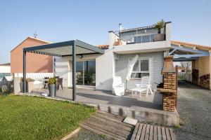 a white house with a patio with white chairs at Villa Lavande in Yves