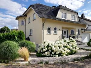 una casa con un gran arbusto blanco delante de ella en Eifelpause, en Plaidt