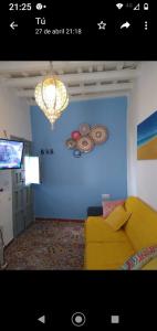 a living room with a yellow couch and a blue wall at Alojamiento con encanto in Vejer de la Frontera