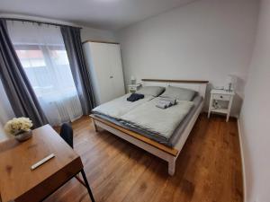 a bedroom with a bed and a table and a desk at Apartmán Blatná in Blatná