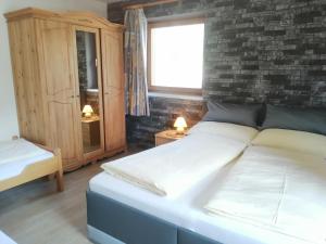a bedroom with a large bed and a brick wall at Haus Sonja in Lermoos