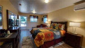 um quarto com uma cama, uma secretária e uma televisão em Little Valley Inn em Mariposa
