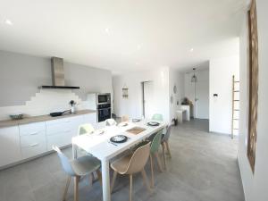 a kitchen and dining room with a white table and chairs at Belle maison de 140m2, proche centre ville in Challans