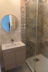 uma casa de banho com um lavatório e um chuveiro com um espelho. em Vagabondes chambres d'hôtes em Azay-le-Rideau