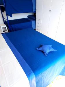 ein blaues Bett mit einem Kissen darauf in der Unterkunft Casa Cornice in Arma di Taggia