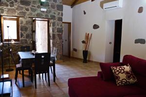 a living room with a red couch and a table at El Rinconcito de Tejeda in Tejeda