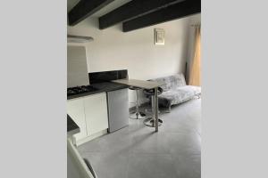 - une cuisine avec une table et un canapé dans une chambre dans l'établissement Joli studio avec jacuzzi et terrasse privée, à Junas