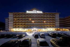 a hotel with cars parked in a parking lot at Apartman Moderna Donovaly in Donovaly
