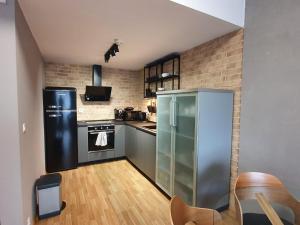 a kitchen with stainless steel appliances and a brick wall at Apartman Moderna Donovaly in Donovaly