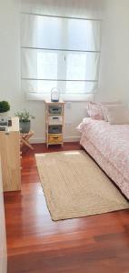 1 dormitorio con cama, ventana y alfombra en Acogedor y luminoso apartamento en Neguri en Getxo