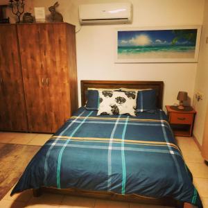 um quarto com uma cama e um armário de madeira em Cute Apartment hagoshrim em Hagoshrim