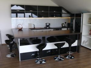 a kitchen with black and white cabinets and bar stools at Villa Princess Maria in Balchik