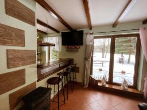 a kitchen with a bar with stools and a television at Sielanka Kretowiny in Kretowiny