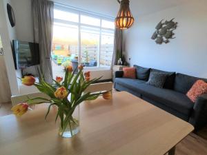 a living room with a vase of flowers on a table at Casa Nuestra in Egmond aan Zee