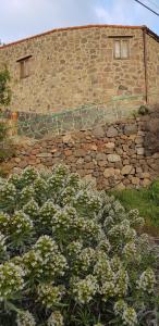 a stone wall with a window and some flowers at El Rinconcito de Tejeda in Tejeda