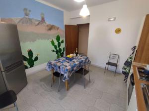 a dining room with a table and a painting on the wall at Casa Vacanza SalGiò in Riposto