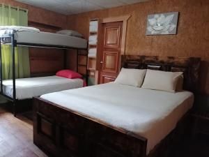 2 Betten in einem Zimmer mit 2 Etagenbetten in der Unterkunft Boquete Town Hostal in Boquete