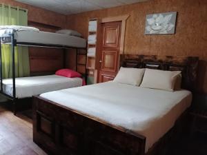 two beds in a room with two bunk beds at Boquete Town Hostal in Boquete