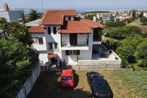 two cars parked in front of a house at Traditional villa appartment with garden, also for gatherings ,15 minutes from Thessaloniki airport in Thessaloniki