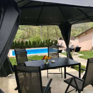 a patio with a table and chairs under a tent at Drinska Idila apartmani in Vrhpolje