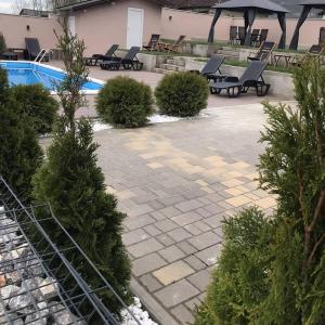 a patio with a pool and chairs and trees at Drinska Idila apartmani in Vrhpolje +31 photos