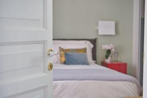 ein Schlafzimmer mit einem weißen Bett und einem blauen Kissen in der Unterkunft Archè Design Rooms and Suites in Palermo
