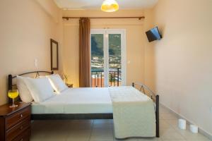 a bedroom with a bed and a window with a balcony at Liotrivi Studios in Vasiliki