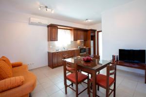 a kitchen with a table and chairs and a television at Liotrivi Studios in Vasiliki
