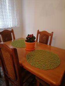 una mesa de madera con una maceta de flores naranjas. en Jaca 2, en Požarevac