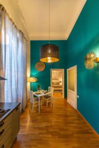 uma sala de jantar com uma mesa e uma parede azul em Flamingo Florence Suite em Florença