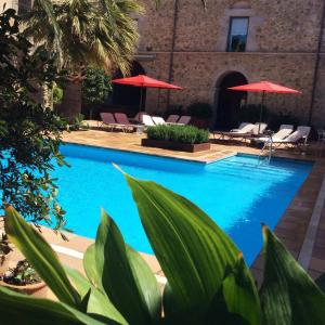 una piscina con sillas y sombrillas en Hotel Canet en Castelló d'Empúries