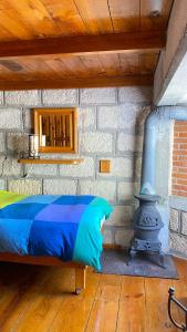 1 dormitorio con cama y pared de ladrillo en Cabañas 5 Pinos en Pinal de Amoles