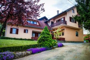 Una casa grande con flores delante de ella. en Apartments and Rooms Štefanac, en Slunj