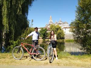 a man and a woman standing next to their bikes at Chambre Marguerite, B&B au 1er- Villa Chaumonty in Périgueux